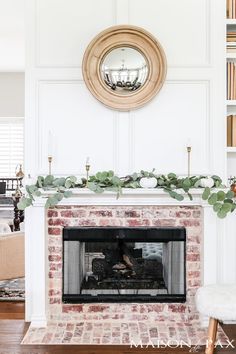 the fireplace is decorated with greenery and candles