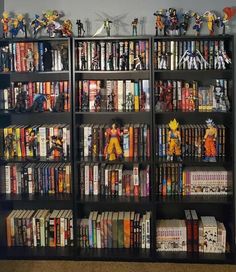 a bookshelf filled with lots of anime figurines on top of it