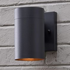 an outdoor light mounted on the side of a brick wall