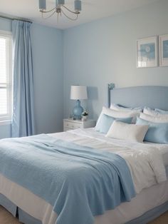 a bedroom with blue walls and white bedding