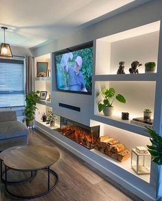 a living room filled with furniture and a flat screen tv mounted on the wall above a fire place