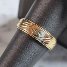 a close up of a gold ring on top of a black piece of cloth,