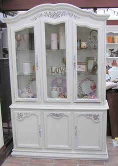 a white china cabinet with lots of glass doors