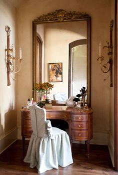 a dressing table with a chair and mirror