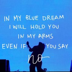 a person standing in front of a blue screen with words on it that read, i'm my blue dream i will hold you in my arms even if you say not