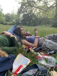 two people laying in the grass on blankets