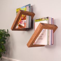 two wooden bookshelves mounted to the wall with magazine holders on each one side