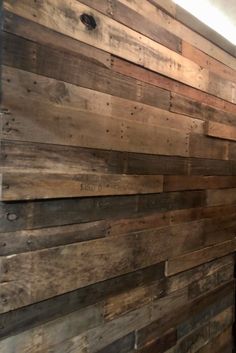 a bathroom with wooden planks on the wall, and a toilet in the corner