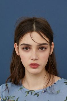 a close up of a person wearing a blue shirt with flowers on it's sleeves