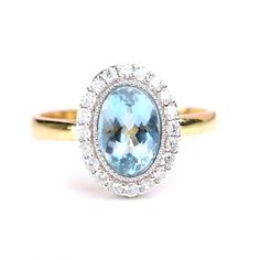 an oval cut blue topaz ring with diamond halos in yellow gold and white gold