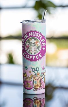 a pink starbucks cup sitting on top of a table