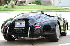 a black sports car parked in front of a house