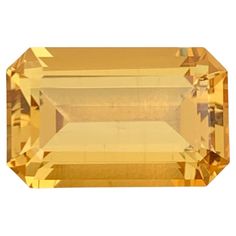 an orange and yellow sapphire stone on a white background with the top section showing it's large, rectangular shape