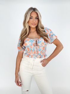 Introducing the Coral Blooms Top, a must-have for any fashion-forward individual. With its front tie detail, smocked sweetheart neckline, and bold floral print, this top exudes elegance and sophistication. Made with a soft and stretchy fabric, it provides both comfort and style. Perfect for a brunch date, dinner, or drinks, this cropped bustier top adds a pop of color to any outfit. Wear it during spring or summer, or pack it for your next tropical vacation for a touch of sunshine and happiness. Brunch Date, Bold Floral Print, The Coral, Date Dinner, Tropical Vacation, Bustier Top, Stretchy Fabric, Sweetheart Neckline, Smocking