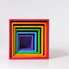 a multicolored wooden block sitting on top of a white surface