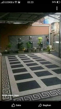 an indoor area with black and white tiles on the floor, potted plants in pots