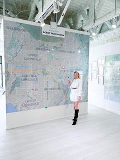 a woman standing in front of a large map