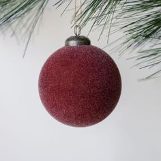 a red ornament hanging from a christmas tree