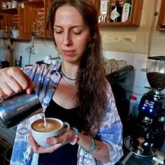 a woman is pouring something into a cup