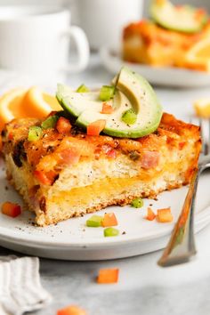 a slice of lasagna on a plate with orange slices and cucumbers