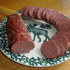 a plate that has some sausages on it and a knife in the middle of it