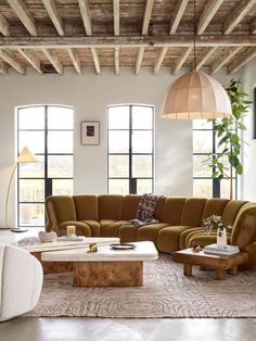 a living room filled with lots of furniture and large windows in the wall behind it