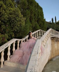 a woman in a pink dress is sitting on some stairs