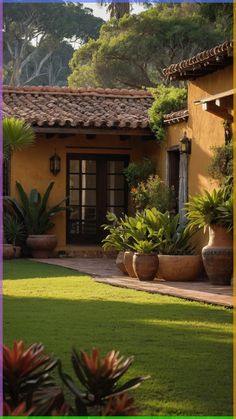 a yellow house with potted plants in the front yard