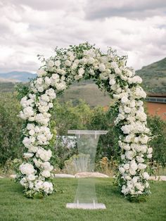 an outdoor ceremony with white flowers and greenery