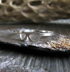 This unique dainty sterling silver ring is handcrafted from 20 gauge sterling silver sheet. The Details ∞ Artisan handmade jewelry ∞ 20 gauge handmade ring band (approx 4.5mm tall at the glasses, 1.2mm band) ∞ Extremely dainty and lightweight ∞ Sterling silver ~ brushed ∞ Choose ring size at checkout ∞ Made to order ∞ Gift box included ∞ Made in the USA There is a charge for the re-sizing of rings, please make sure of your proper ring size before placing your order to avoid a fee if re-sizing is Handmade Modern Sterling Silver Midi Rings, Modern Handmade Sterling Silver Midi Rings, Modern Handmade Silver Midi Rings, Artisan Jewelry Handmade, Prescott Az, Ring Band, Eye Glasses, Real Diamonds, Earrings Handmade