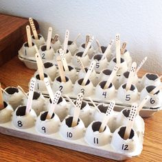 an egg carton filled with lots of eggs and wooden skewers on top of it