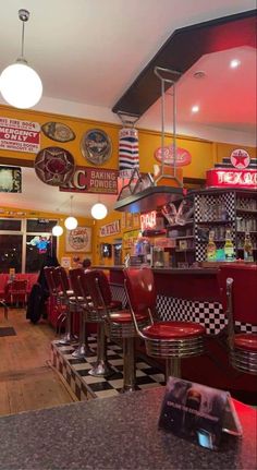 the interior of a diner with red chairs and checkered flooring on the walls