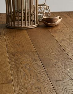 a birdcage sitting on top of a wooden floor