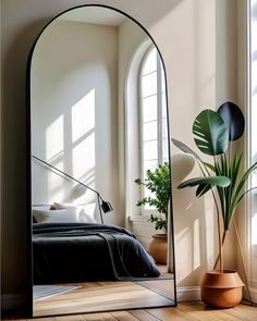 a bedroom with a large mirror on the wall next to a bed and potted plant