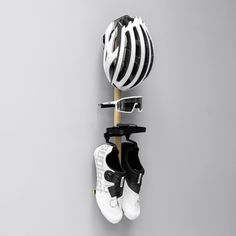 a pair of shoes hanging on a wall next to a helmet and eyeglass holder