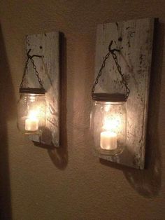 two mason jar lights are hanging on the wall