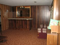 an empty living room with wood paneling on the walls