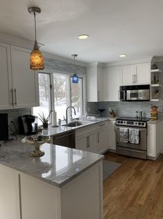 a kitchen with white cabinets and stainless steel appliances