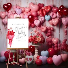 a welcome baby shower sign surrounded by heart shaped balloons and flowers in front of a backdrop