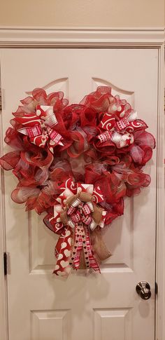 a red and white wreath hanging on the front door