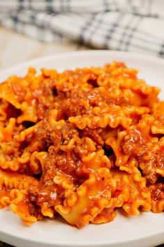 a white plate topped with pasta covered in sauce