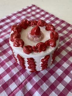 a red and white checkered table cloth with a heart shaped cake in the center