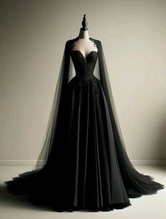 a black dress with long sleeves and a veil