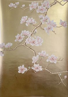 a gold pillow with pink flowers painted on the front and back of it, sitting on a bed