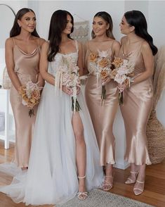 three bridesmaids in champagne colored dresses standing next to each other and holding bouquets