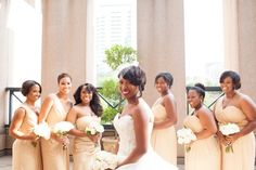 a group of women standing next to each other in front of a window holding bouquets