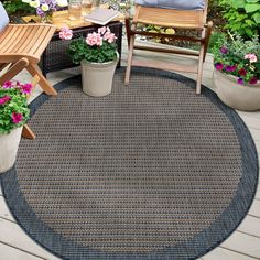 an outdoor area rug with chairs and potted plants on the deck in front of it