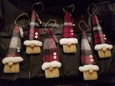 six christmas gnomes are hanging on a black piece of cloth with white and red trim