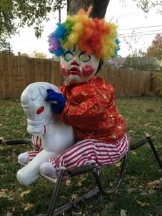 a clown sitting on top of a white horse in the grass next to a tree