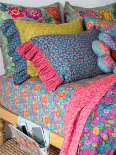 a bed with colorful pillows and blankets on it